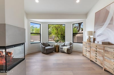 Relaxing lounge area with backyard views, large picture windows, and a contemporary fireplace. This inviting extension of the primary suite offers both elegance and versatility.