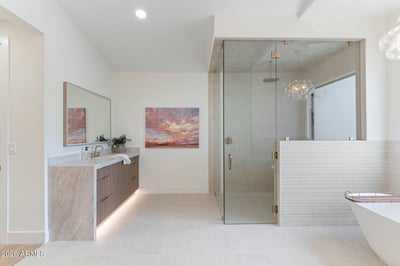Contemporary walk-in shower featuring frameless glass, elegant tilework, rainfall fixtures, and spacious design. Luxury details elevate this exceptional Scottsdale home's primary bath.