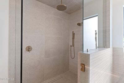 Oversized walk-in shower with premium tile finishes, frameless glass enclosure, rainfall showerhead, and luxury fixtures. Designed to deliver a relaxing spa-like experience.