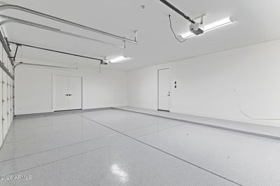 Clean, oversized garage featuring durable epoxy flooring, generous storage space, and room for multiple vehicles. A practical upgrade that enhances everyday living in this Scottsdale property.