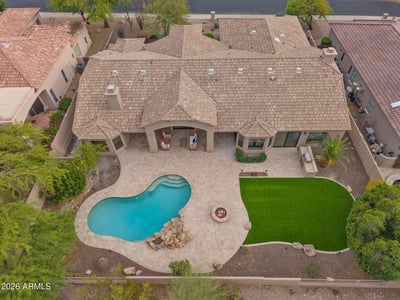 Overhead view highlighting the custom pool, expansive patio, fire pit, covered outdoor living area, artificial turf, and thoughtfully designed backyard in Scottsdale.