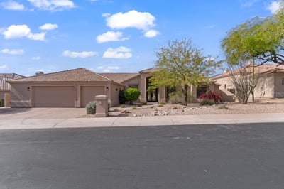 Wide front elevation displaying elegant architecture, generous driveway, and attractive desert landscaping. This beautifully updated Scottsdale residence combines modern luxury with timeless exterior design.