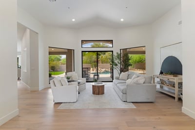 Beautiful great room overlooking the backyard through oversized windows and sliding glass doors. The seamless connection between indoor and outdoor living enhances the home's luxurious Scottsdale lifestyle.