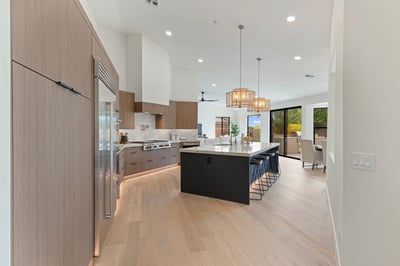Stunning gourmet kitchen with premium Wolf and Sub-Zero appliances, a large waterfall island, custom cabinetry, and designer lighting. The open layout creates the perfect space for entertaining and everyday living in Scottsdale.