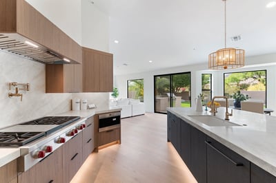 Expansive quartz island anchors this luxurious kitchen featuring premium appliances, custom cabinetry, designer finishes, and an open floor plan ideal for gathering with family and friends.
