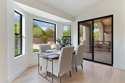 Sunny breakfast area with oversized windows and sliding glass doors overlooking the covered patio and backyard. A perfect spot to enjoy casual dining while embracing Scottsdale's indoor-outdoor lifestyle.