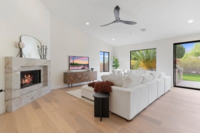 Elegant family room highlighted by a modern fireplace, soaring ceilings, oversized windows, and beautiful backyard views. Designed for comfortable living and effortless entertaining.