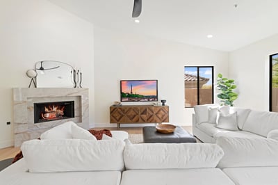 Inviting living room featuring a sleek fireplace, modern finishes, and expansive windows that fill the space with natural light. An ideal setting for relaxing or entertaining guests.
