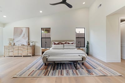 Elegant primary bedroom offering expansive living space, vaulted ceilings, oversized windows, and modern finishes. A peaceful retreat designed with style and functionality in mind.