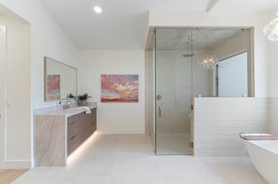 Contemporary walk-in shower featuring frameless glass, elegant tilework, rainfall fixtures, and spacious design. Luxury details elevate this exceptional Scottsdale home's primary bath.