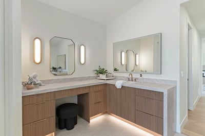 Sophisticated vanity area with custom wood cabinetry, quartz countertops, modern mirrors, and designer lighting. An elegant space offering beauty, storage, and functionality.