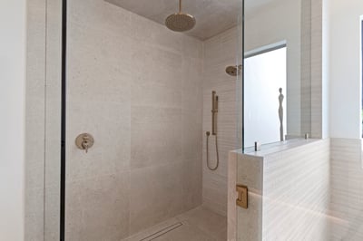 Oversized walk-in shower with premium tile finishes, frameless glass enclosure, rainfall showerhead, and luxury fixtures. Designed to deliver a relaxing spa-like experience.