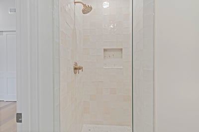 Bright walk-in shower with premium tile finishes, frameless glass, and built-in niche for convenience. This beautifully appointed Scottsdale home offers luxurious bathrooms and designer upgrades.
