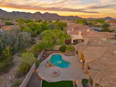Elevated aerial view highlighting the pool, spacious patio, mature desert landscaping, and surrounding mountain scenery that make this Scottsdale property truly exceptional.