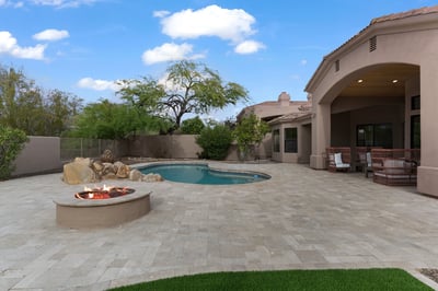 Expansive backyard with a custom fire pit, sparkling pool, spacious entertaining patio, and covered outdoor seating. Designed to maximize Scottsdale's beautiful outdoor lifestyle with luxury amenities.