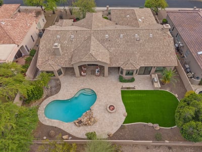 Overhead view highlighting the custom pool, expansive patio, fire pit, covered outdoor living area, artificial turf, and thoughtfully designed backyard in Scottsdale.