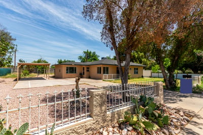 The side exterior reveals additional green space, backyard access, and mature landscaping surrounding this oversized property. Buyers will appreciate the flexibility and usable outdoor areas this Mesa home provides.