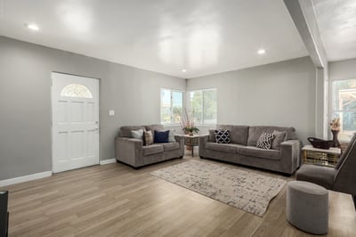 Natural light fills this spacious living room, showcasing updated wood-look flooring, recessed lighting, and neutral finishes throughout. The open, move-in-ready design creates a warm and comfortable gathering space for family and guests.
