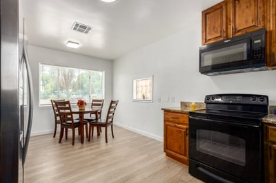 Granite countertops, rich wood cabinetry, built-in appliances, and generous storage make this kitchen both beautiful and functional. The spacious layout provides an ideal setting for meal preparation and entertaining.