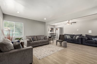 This spacious living area offers an open layout with updated wood-look flooring, recessed lighting, and excellent flow throughout the home. Large windows create a bright and inviting atmosphere perfect for entertaining and everyday living.