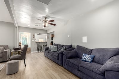 The family room features generous seating space, a ceiling fan, updated flooring, and an open connection to the breakfast bar and kitchen. Its spacious layout makes it ideal for relaxing or hosting family and friends.