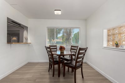 Another perspective of the dining room highlights the spacious layout, abundant natural light, and convenient connection to the breakfast bar and kitchen. The open design supports comfortable everyday living.