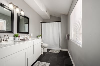 Bright ensuite bathroom showcasing a double-sink vanity, updated fixtures, modern cabinetry, and generous natural light. Designed for comfort and everyday convenience in this Mesa property.