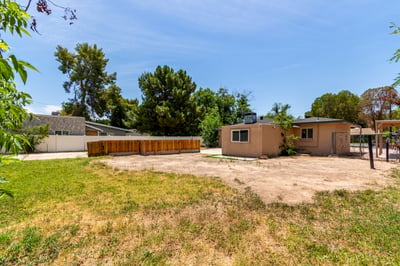 Broad view of the oversized backyard with open green space, mature landscaping, and room to create your ideal outdoor retreat. A versatile outdoor environment enhances this Mesa home.
