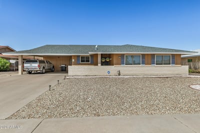 Attractive Sun City home with fresh exterior appeal, a new roof, covered golf cart parking, spacious driveway, and easy-care desert landscaping designed for low-maintenance living.