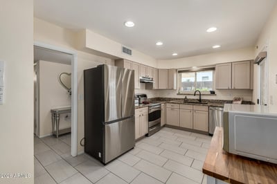 Well-appointed kitchen with granite counters, stainless steel appliances, recessed lighting, abundant cabinet storage, and a bright workspace designed for daily functionality.