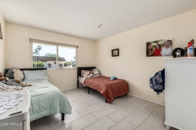 Spacious secondary bedroom featuring a large window, tile flooring, and flexible living space ideal for guests, hobbies, or everyday comfort.