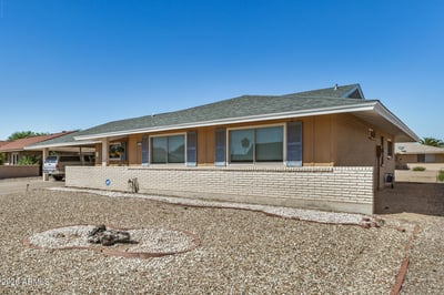 Beautiful exterior angle showcasing the home's updated roof, attractive architectural details, low-maintenance desert landscaping, and welcoming curb appeal.