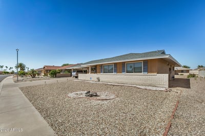 Attractive front fa ade features a broad driveway, covered parking, and professionally maintained desert landscaping. This Sun City property welcomes guests with timeless curb appeal.