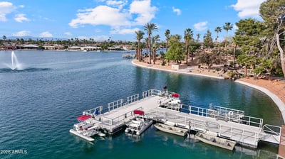 Beautiful aerial captures the nearby marina with boat docks, tranquil lake views, and landscaped shoreline. Enjoy convenient waterfront recreation in desirable Sun City.