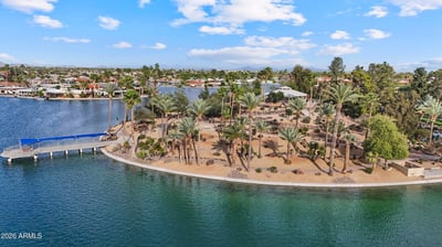 Scenic aerial highlights lakeside walking paths, mature palm trees, landscaped park areas, and peaceful waterfront surroundings. Sun City offers exceptional outdoor spaces just minutes away.