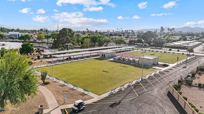 Aerial image features nearby lawn bowling greens, gathering areas, and landscaped recreation spaces. Sun City provides a variety of outdoor amenities for recreation and leisure.