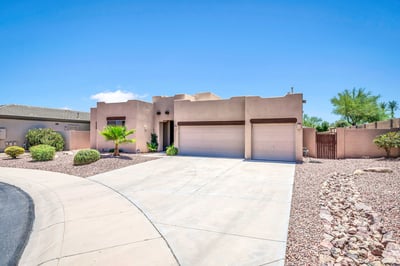 Front exterior showcasing the expansive driveway, attached 3-car garage, and easy-maintenance landscaping. A welcoming first impression that complements this energy-efficient Palm Valley home.