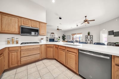 Open kitchen featuring a large breakfast bar, stainless appliances, gas cooktop, and abundant workspace overlooking the main living area. Ideal for casual dining and entertaining guests.