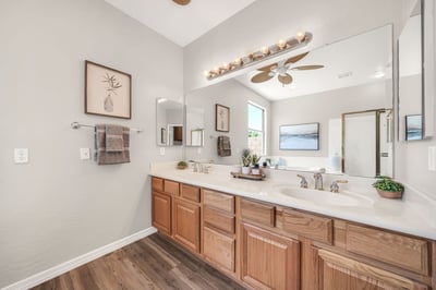 Elegant owner's bathroom with dual sinks, extensive counter space, and abundant storage creates a functional and inviting morning routine. High ceilings and natural light enhance the room's spacious feel.