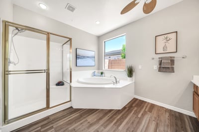 The owner's ensuite features a relaxing soaking tub, separate walk-in shower, and bright window that fills the space with natural light. A private retreat designed for everyday comfort.