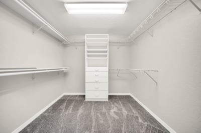 Expansive walk-in closet with multiple hanging areas, built-in drawers, and shelving keeps everything neatly organized. An impressive storage feature within the owner's suite.