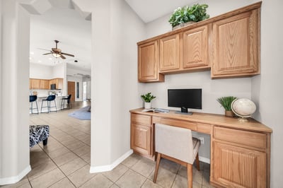 Built-in desk with upper and lower cabinetry creates a practical workspace for remote work, homework, or hobbies. This versatile feature adds flexibility to the home's open floor plan.