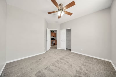 Bright secondary bedroom featuring plush carpet, ceiling fan, and generous space for family or overnight guests. A versatile room suited for multiple lifestyle needs.