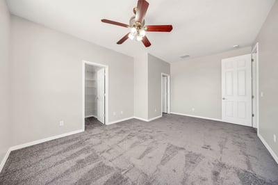 Spacious secondary bedroom with plush carpeting, ceiling fan, and a walk-in closet, offering flexibility for guests, family, or a dedicated workspace. Designed to fit a variety of lifestyle needs.