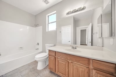 Well-appointed guest bathroom featuring a full tub and shower combination, spacious vanity, and natural light. Conveniently positioned to provide comfort and privacy for overnight guests.