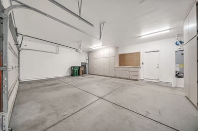 Large attached 3-car garage with extensive built-in cabinetry, workbench, and organized storage solutions. Ideal for projects, hobbies, and keeping everything neatly arranged.