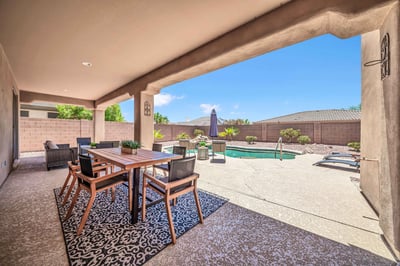 Enjoy outdoor dining beneath the covered patio while overlooking the PebbleTec pool, waterfall, and professionally landscaped backyard. This inviting outdoor space offers the ideal blend of comfort, privacy, and Arizona-style living.