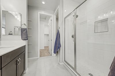 Modern primary bath featuring a beautifully tiled walk-in shower with glass enclosure, built-in storage niche, quartz vanity, and upscale finishes. A clean, contemporary space designed for daily comfort and relaxation.