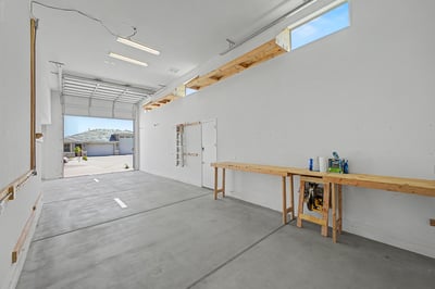 Functional RV garage with built-in workbench, overhead storage, oversized garage door, and expansive floor space. Perfect for hobbies, projects, additional storage, or oversized vehicle parking.