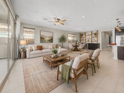 Virtually Staged Spacious great room with recessed lighting, ceiling fan, and oversized sliding glass doors that connect indoor and outdoor living. The custom built-in entertainment area adds both style and functionality.
